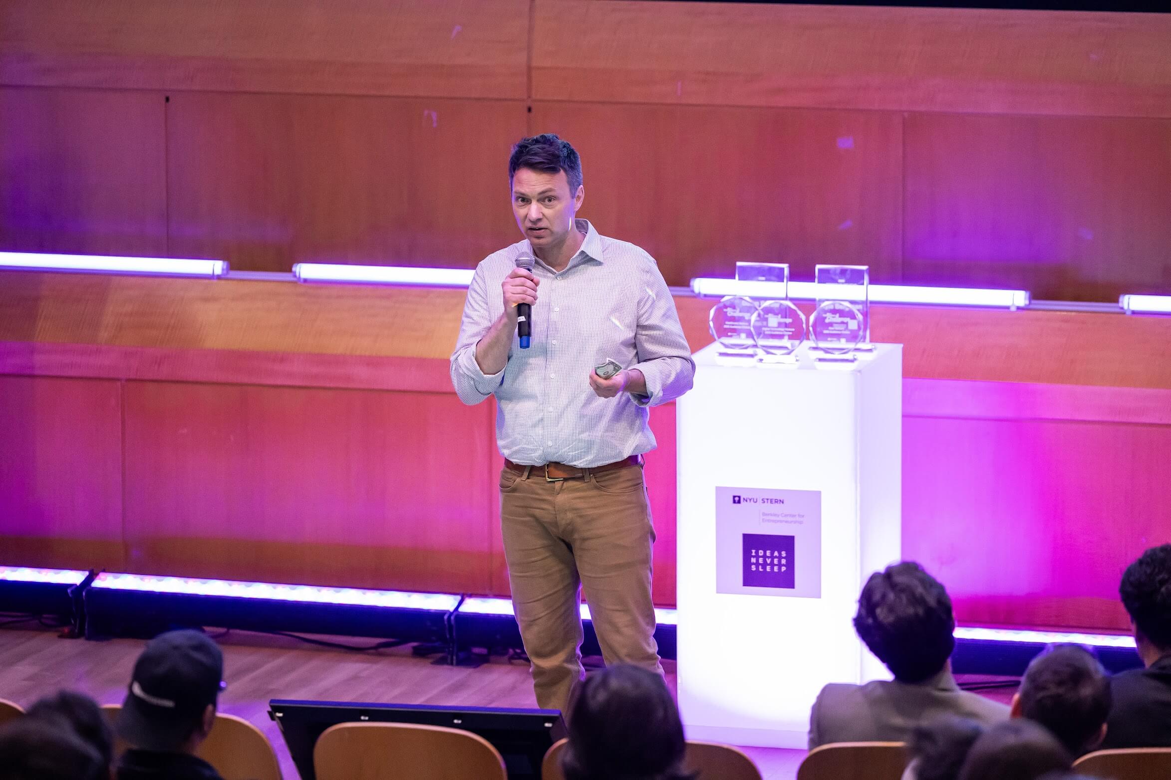 Michael speaking on stage at NYU Stern